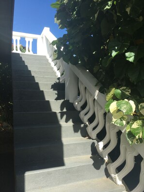 A staircase with a white balustrade and a view of a building in the background.
