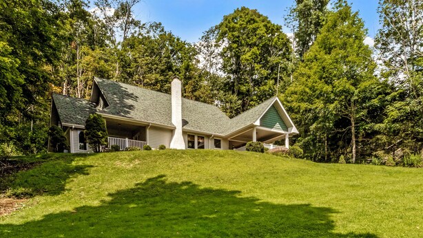 A house with a sloped roof, a covered porch, and a well-maintained lawn. - Walk to Ski Lodge..Mountain Views..Includes Ski Lodge Locker (Sugar Mountain)