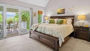 A bedroom with a bed, a nightstand, a lamp, a ceiling fan, and a view of the outdoors. - Walk to Ski Lodge..Mountain Views..Includes Ski Lodge Locker (Sugar Mountain)
