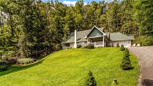 A house with a sloped roof, a front porch, and a well-maintained lawn. - Walk to Ski Lodge..Mountain Views..Includes Ski Lodge Locker (Sugar Mountain)