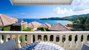A balcony with a view of a beach and ocean. - Luxurious 7-bedroom villa with spectacular sea view and private pool (Tower Isle)