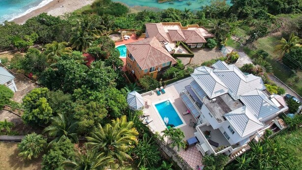 An aerial view of a resort with a pool, beach access, and lush greenery. - Luxurious 7-bedroom villa with spectacular sea view and private pool (Tower Isle)