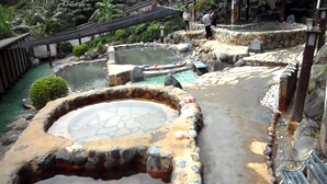 A hot spring area with multiple pools surrounded by stone walls and a wooden bridge. - Freestyle A Sun Yat-san Memorial Hall (Taipei)