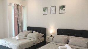 A hotel room with two beds, a nightstand, and a wall with three framed pictures. - Ipoh Paradise Homestay Station 18 (Ipoh)