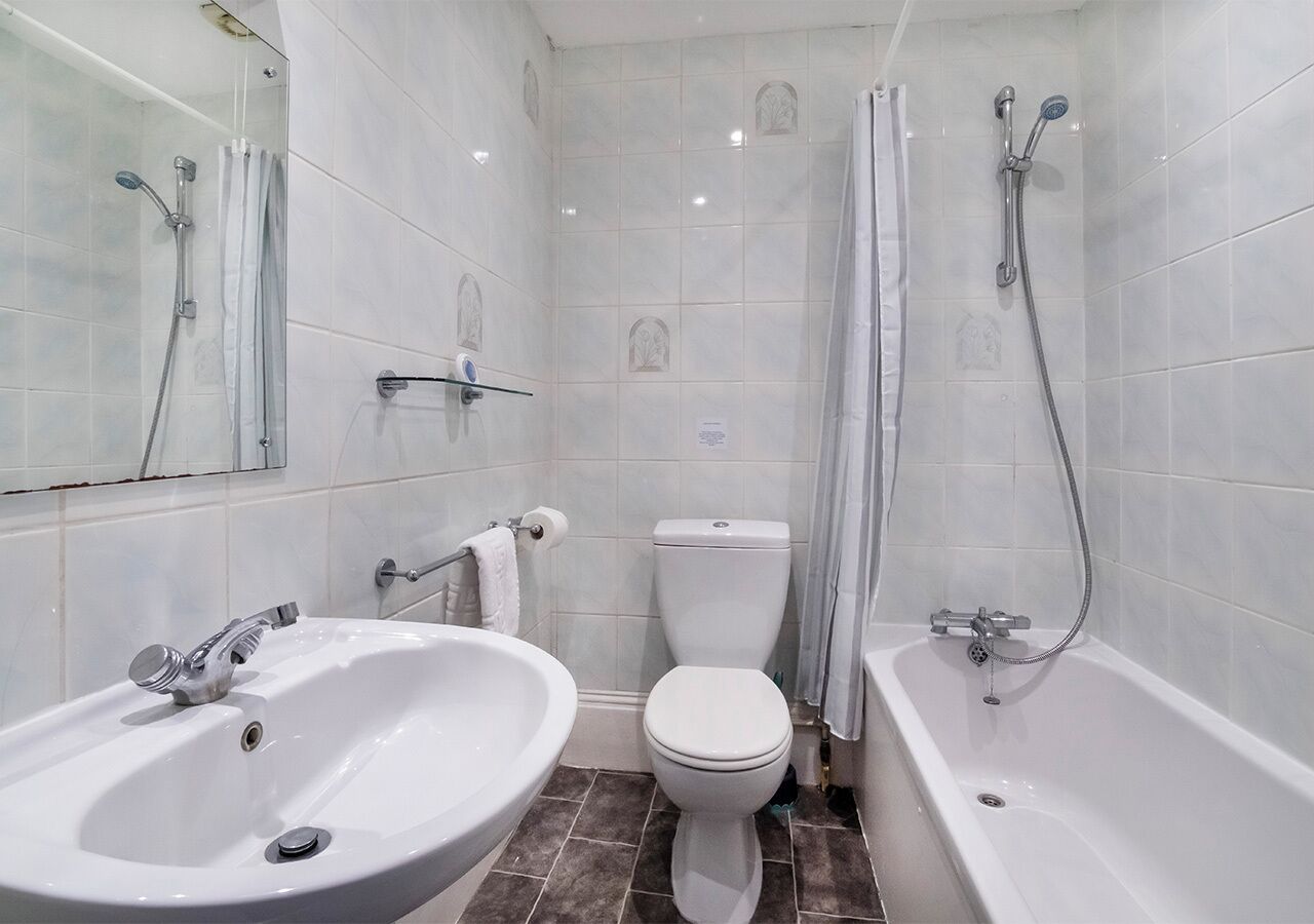 Un baño con lavamanos, inodoro y bañera.