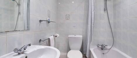 Un baño con lavamanos, inodoro y bañera.