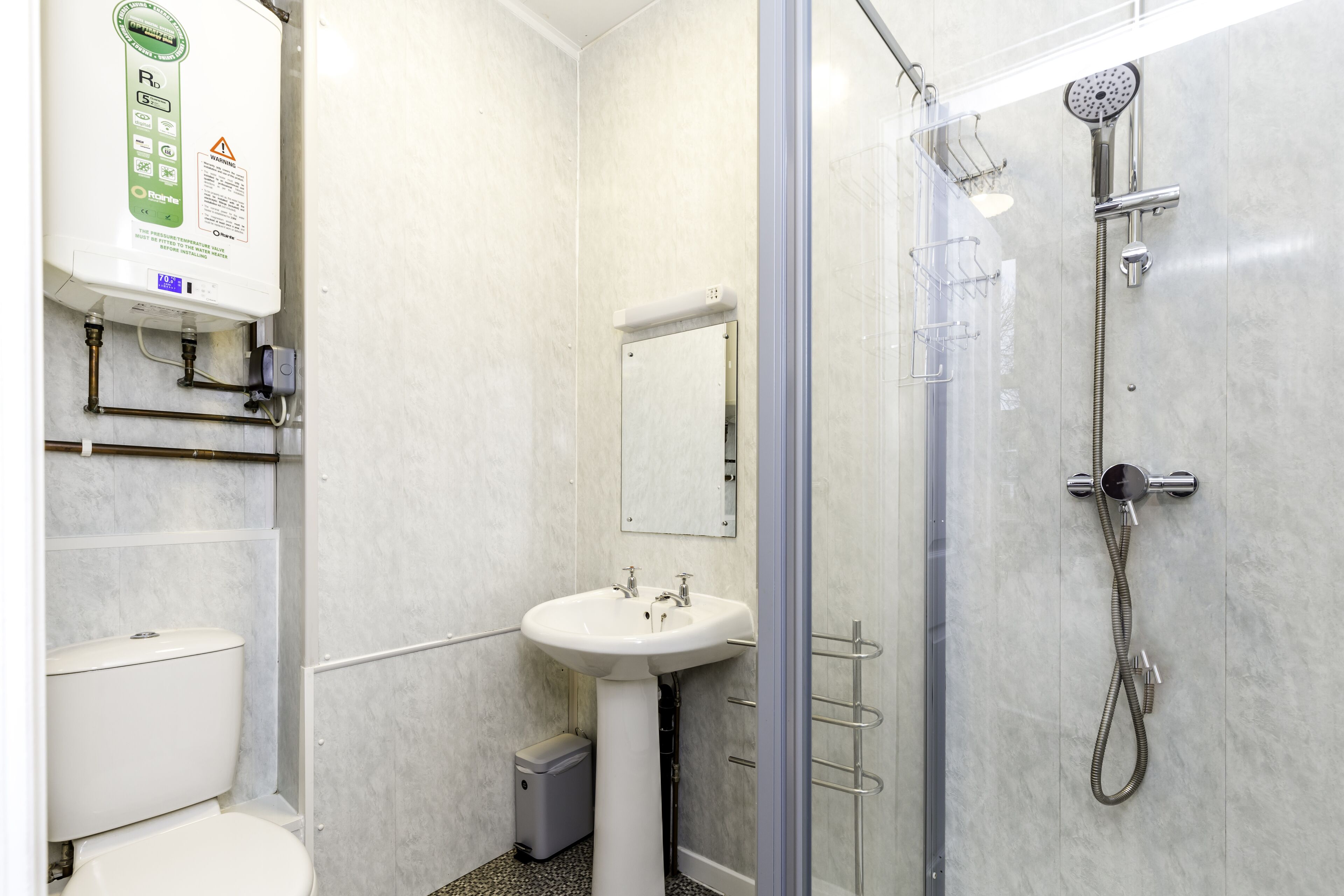 A modern bathroom with a toilet, sink, and shower.