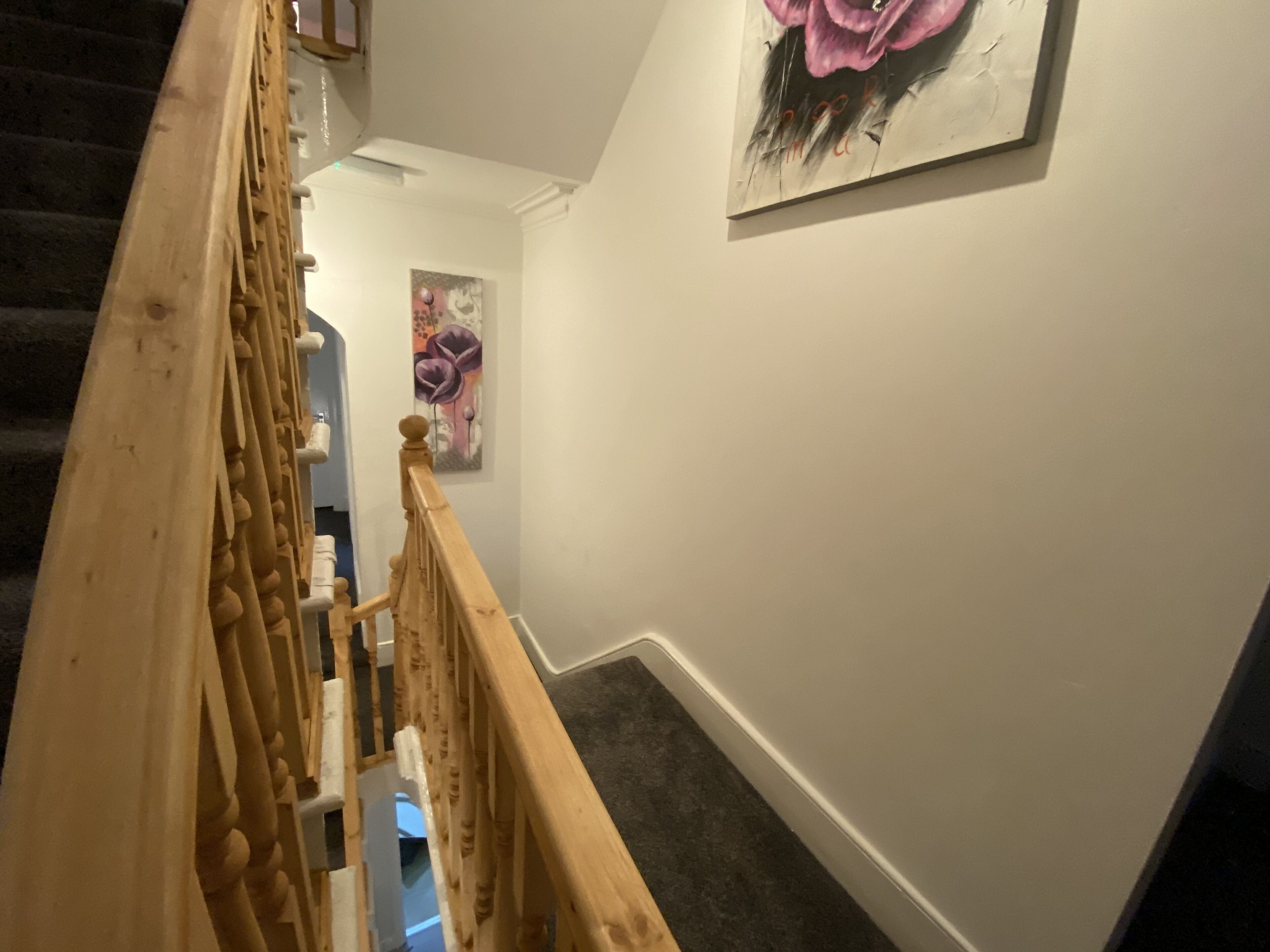 A staircase with wooden railings and a carpeted floor.