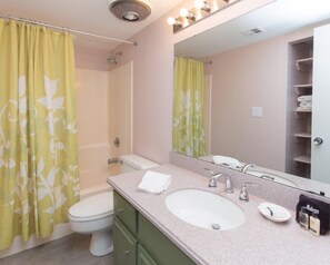 A bathroom with a toilet, sink, and shower curtain. - 2077 Beachwood (Fernandina Beach)