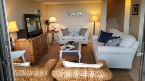 A living room with a sofa, two armchairs, a coffee table, a television, and a lamp. - 1149 Beachwalker (Fernandina Beach)