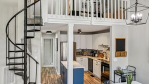 A spacious loft with a mezzanine, a kitchen, and a dining area.