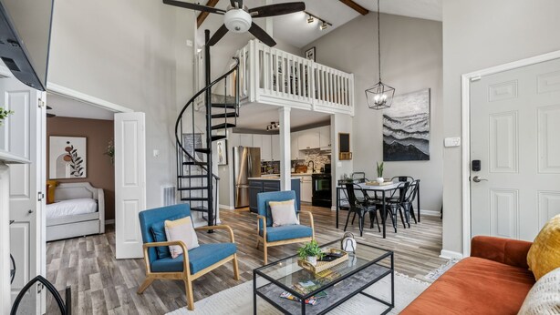 A spacious living area with a loft bedroom, a dining area, and a kitchen.