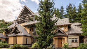 A modern multi-story house with a symmetrical design, featuring a central entrance with a door and windows on either side. - Heavenly 2BR/2BA. Private Hot-tub & Mountain View’s (Whistler)