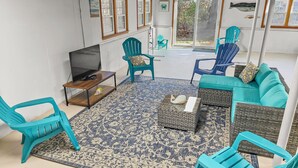A living room with a TV, blue chairs, a sofa, and a patterned rug. - Walk to Beach Central AC WiFi Beach Pearl (Chatham)