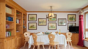 A dining area with a wooden table, chairs, and a bookshelf.