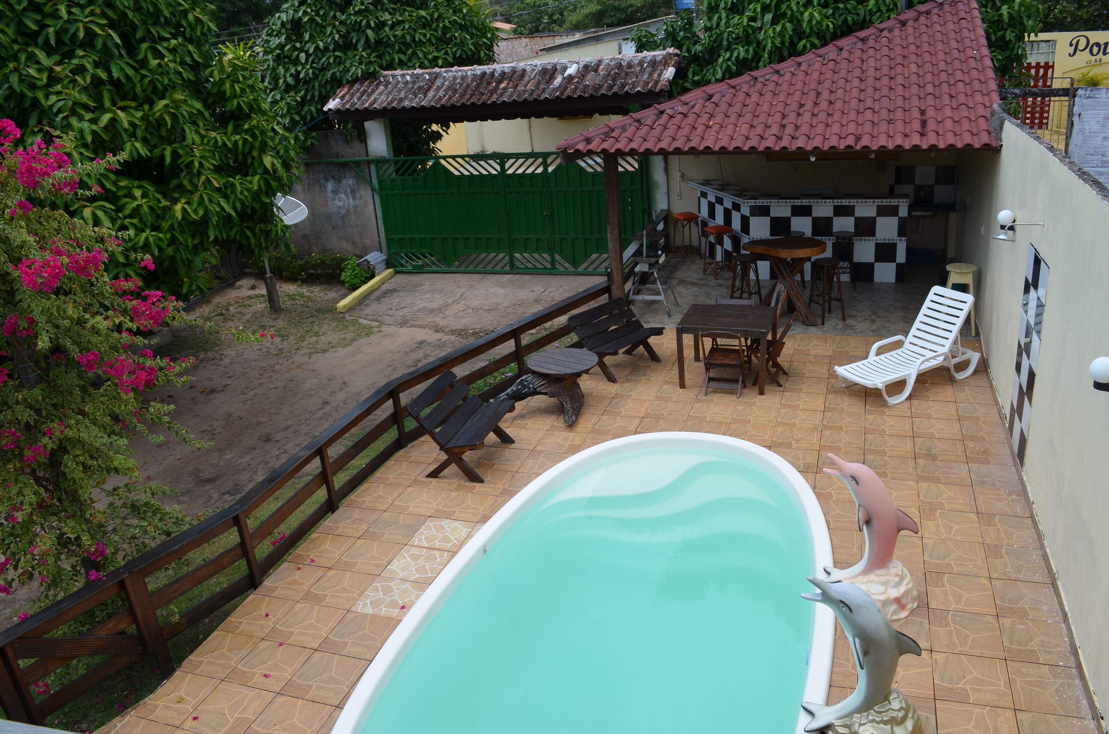 A swimming pool with lounge chairs and a small outdoor kitchen area.