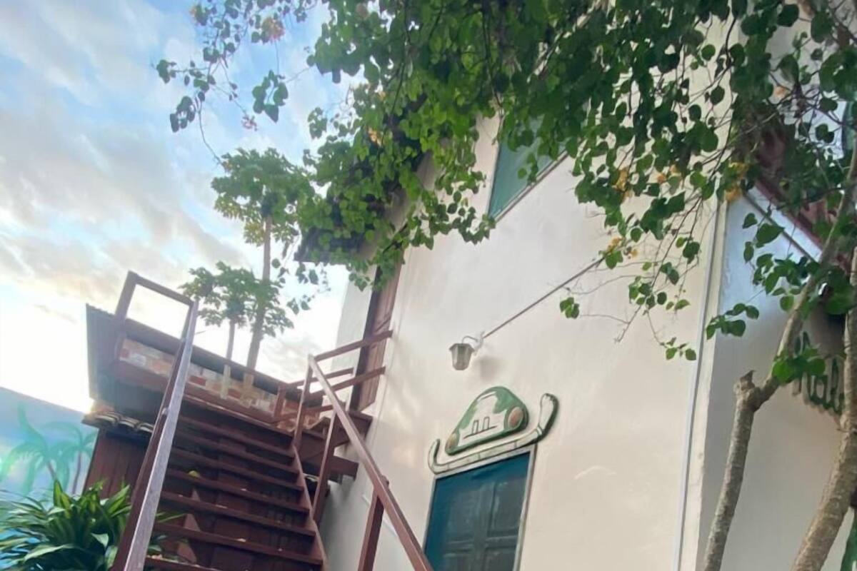 Escadaria que leva a um edifício com uma porta verde e uma pequena janela.