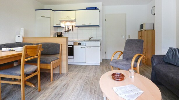 A compact living space with a dining area, kitchenette, and seating area. - Vacationer village 27c, Germany (Ostseebad Boltenhagen)