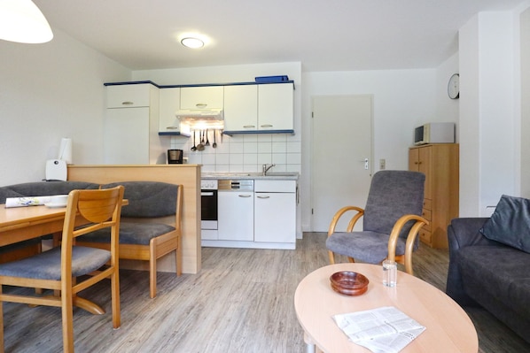A compact living space with a dining area, kitchenette, and seating area.