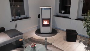 Un salon moderne avec une table basse en verre, un canapé, une cheminée et une plante en pot.