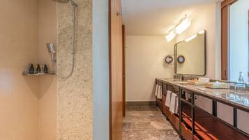 Un baño moderno con ducha, tocador con espejo y un perchero para toallas.