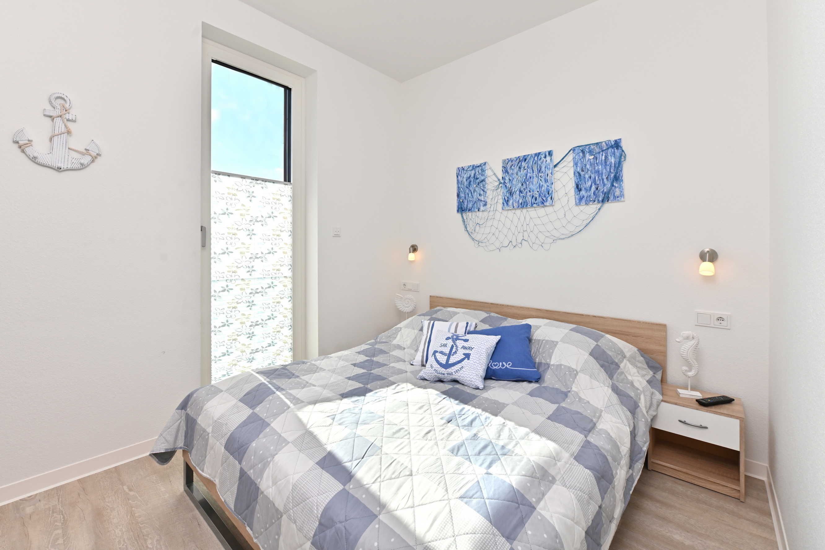 A bedroom with a bed, nightstands, and a window.