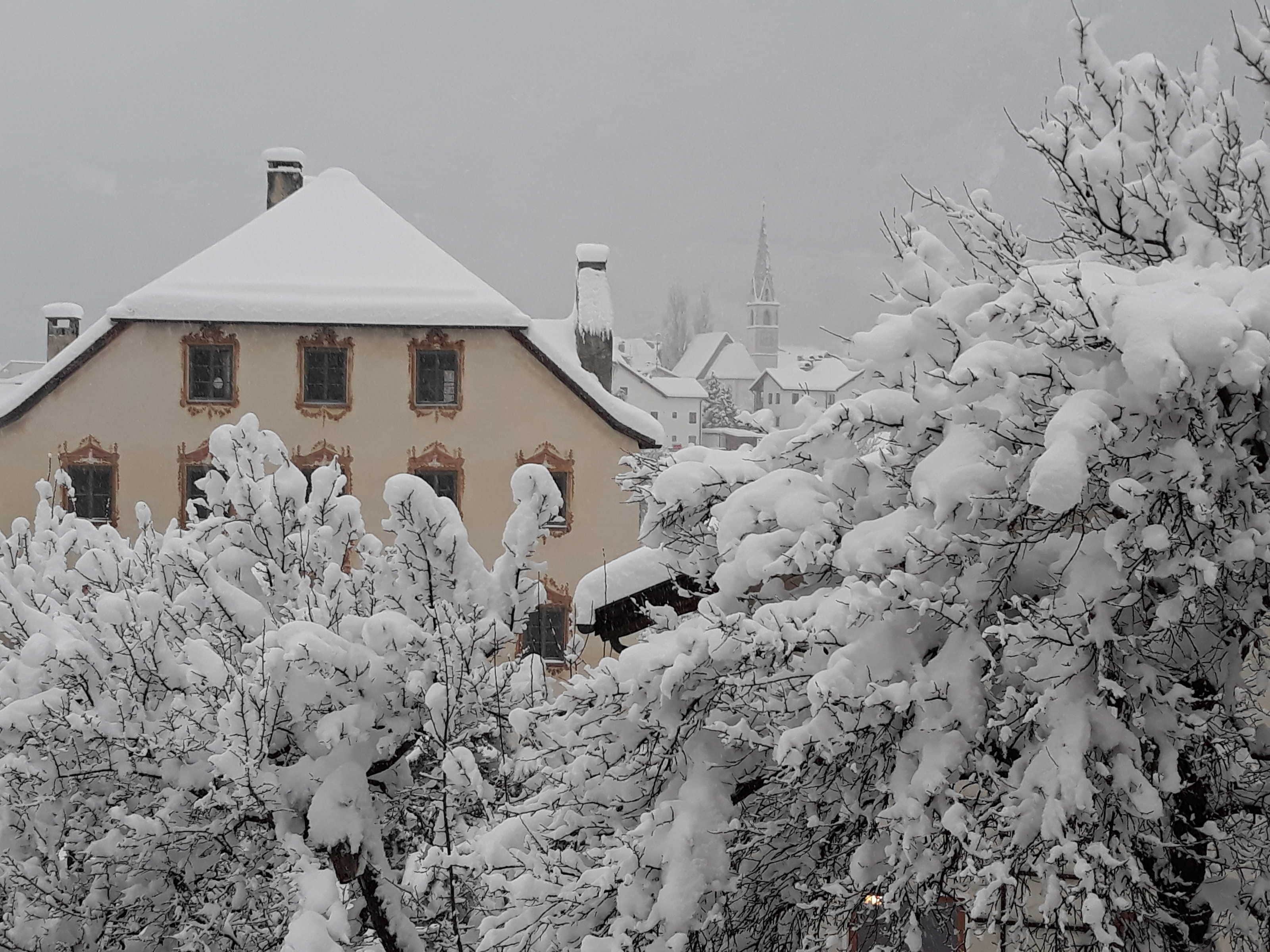 A snow-covered building with multiple windows and a distinct architectural style.