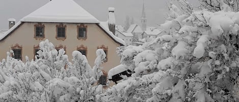 A snow-covered building with multiple windows and a distinct architectural style.