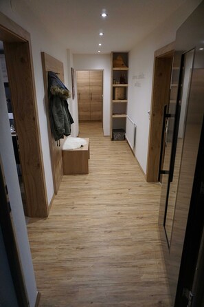 A narrow hallway with wooden flooring, a bench, and a coat rack. - Alblerhof - Apartment (2-5 people) (Pfunds)