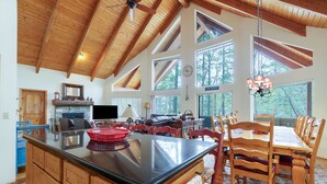 A spacious kitchen with a large island, wooden cabinetry, and a dining area with a wooden table and chairs.