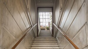 A marble staircase with wooden handrails leading to a door with a window. - La Casa de Bulnes (Buenos Aires)