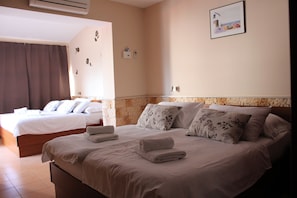 A hotel room with two beds, a brick accent wall, a framed picture, and a wall-mounted air conditioner. - Pansion Dalmacija (Dugi Rat)