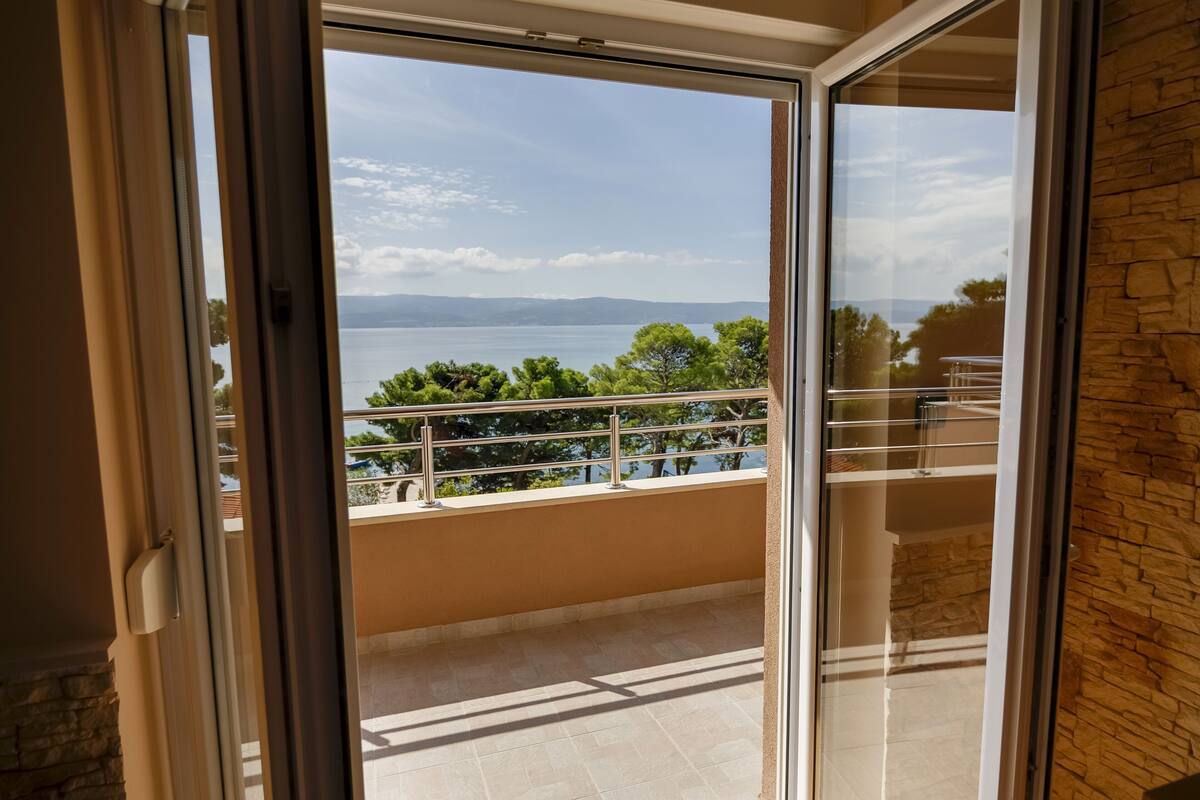 A balcony with a view of a lake and distant mountains.