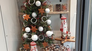 Une décoration de Noël comprenant un arbre décoré, des chocolats et des biscuits.