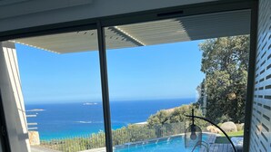 Una camera da letto con vista sull'oceano, una piscina e un ponte in legno.