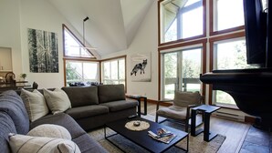 A modern living room with a sectional sofa, a coffee table, and a fireplace.