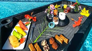 A tray with food and drinks by a poolside.