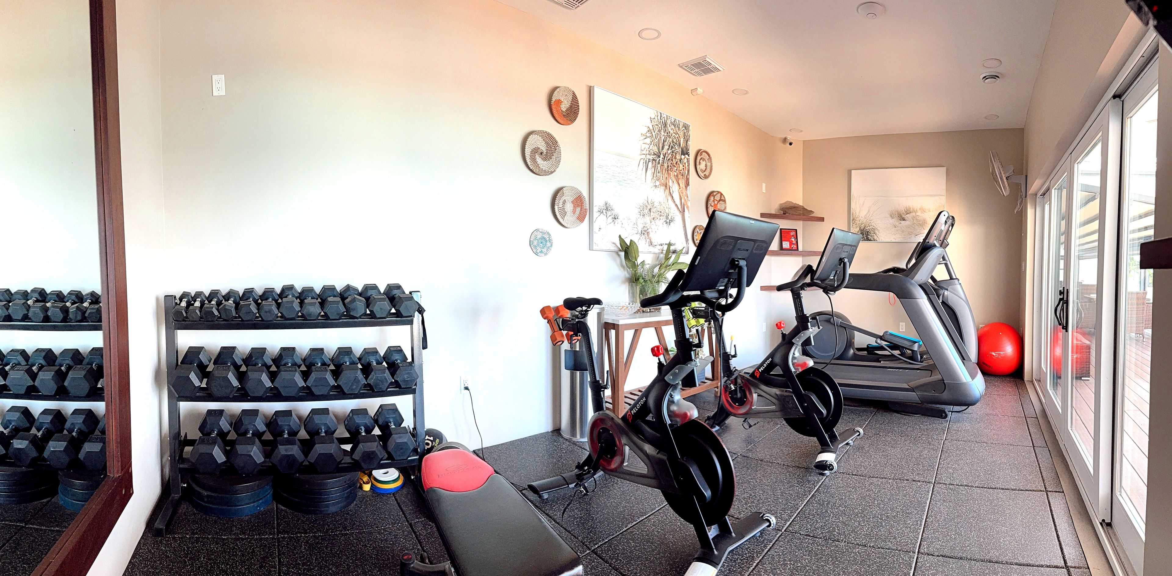 A gym with exercise equipment, a treadmill, and a stationary bike.