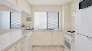 A modern kitchen with a sink, stove, and cabinets.