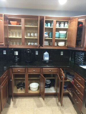 Uma cozinha com armários de madeira, uma cafeteira e um bebedouro.