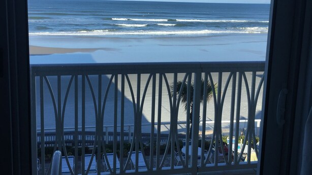 A balcony with a view of the ocean, a tiled floor, and a railing. - Ocean Front, Luxurious 3/3 New Rental (Daytona Beach Shores)