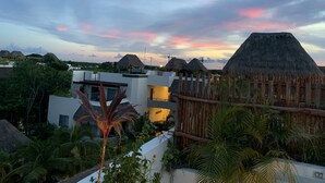 A resort with modern architecture, thatched-roof huts, and lush greenery.