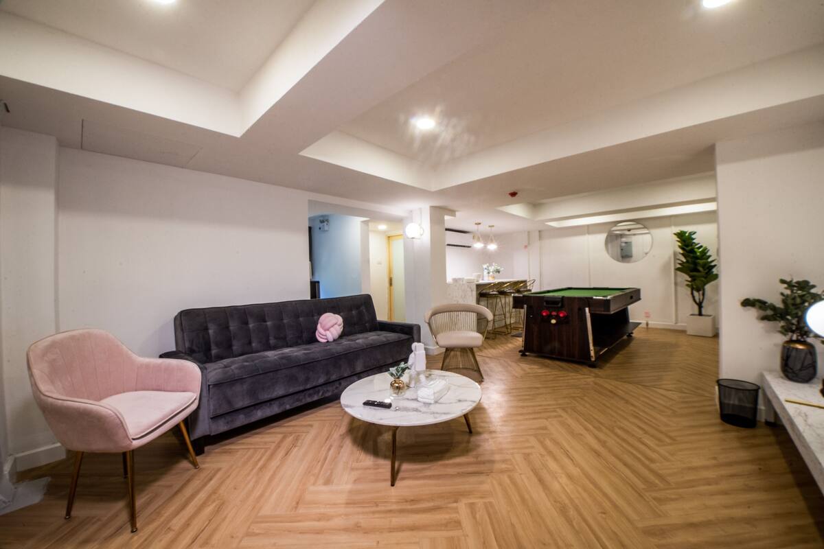 Un saló modern amb billar, un sofà i una taula de centre.
