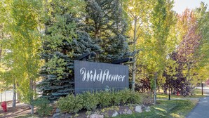 Un letrero con la palabra 'Wildflower' rodeado de árboles y una zona con césped.