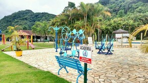 An outdoor fitness area with exercise equipment and a sign indicating it is for exclusive use by mothers over 12 years old. - House in Ubatuba - Gated community | swimming pool | gourmet area | river access (Horto (Morro das Moças))