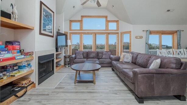 A spacious living room with a fireplace, a large sectional sofa, and a ceiling fan. - 1414 - Hope Sanctuary - Whalehead Corolla Escape | Pool, HotTub & Foosball (Corolla)