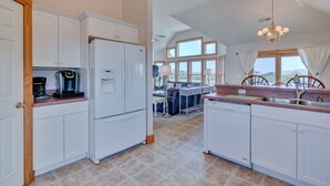 A spacious kitchen with white cabinetry, a built-in dishwasher, and a coffee maker. - 1414 - Hope Sanctuary - Whalehead Corolla Escape | Pool, HotTub & Foosball (Corolla)