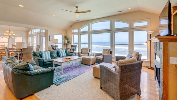 A spacious living room with a large window overlooking the ocean, furnished with a sofa, chairs, and a coffee table. - 2869 - Seascape - Oceanfront Duck Retreat w/ Pool, Hot Tub & Views (Kitty Hawk)