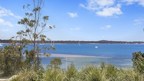 A coastal view with clear water, boats, and a distant shoreline. - First class hidden jewel (Corlette)