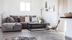 A modern living room with a grey sectional sofa, a black coffee table, a patterned armchair, and a shaggy rug. - Nordic spanish pool villa (Campello)